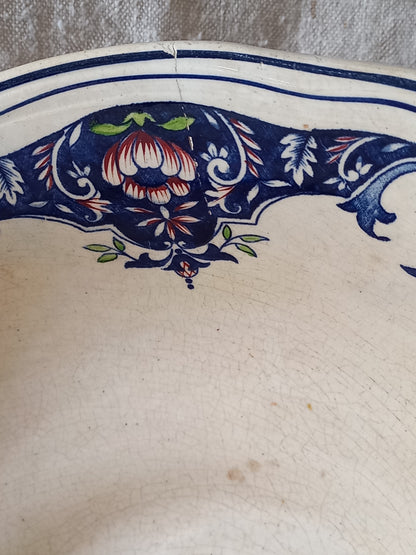 Close-up of a large French antique decorative footed bowl with a stunning floral pattern in a decorative setting.