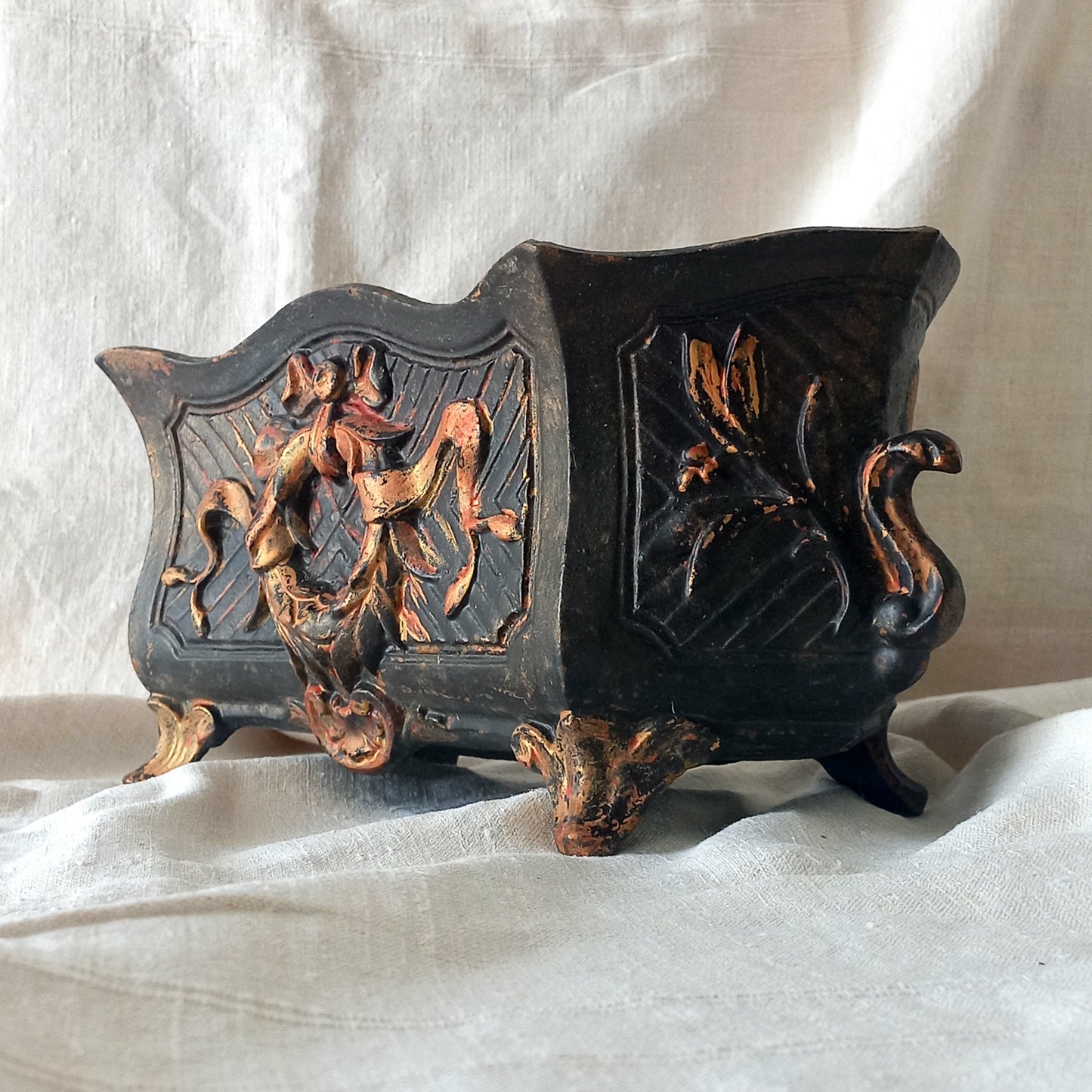 A stunning French antique decorative cast iron planter with patina of age suitable for both interior and exterior use - we rarely come across them these days so this was an exciting find.

The planter is in a striking and wonderfully aged black colour with gold coloured detailing in relief - there's some great paint chipping off areas of the gold paint showing small areas of red beneath, and also chipping from the black paint showing rusty patina, all of which add to the antique character of this beautiful 