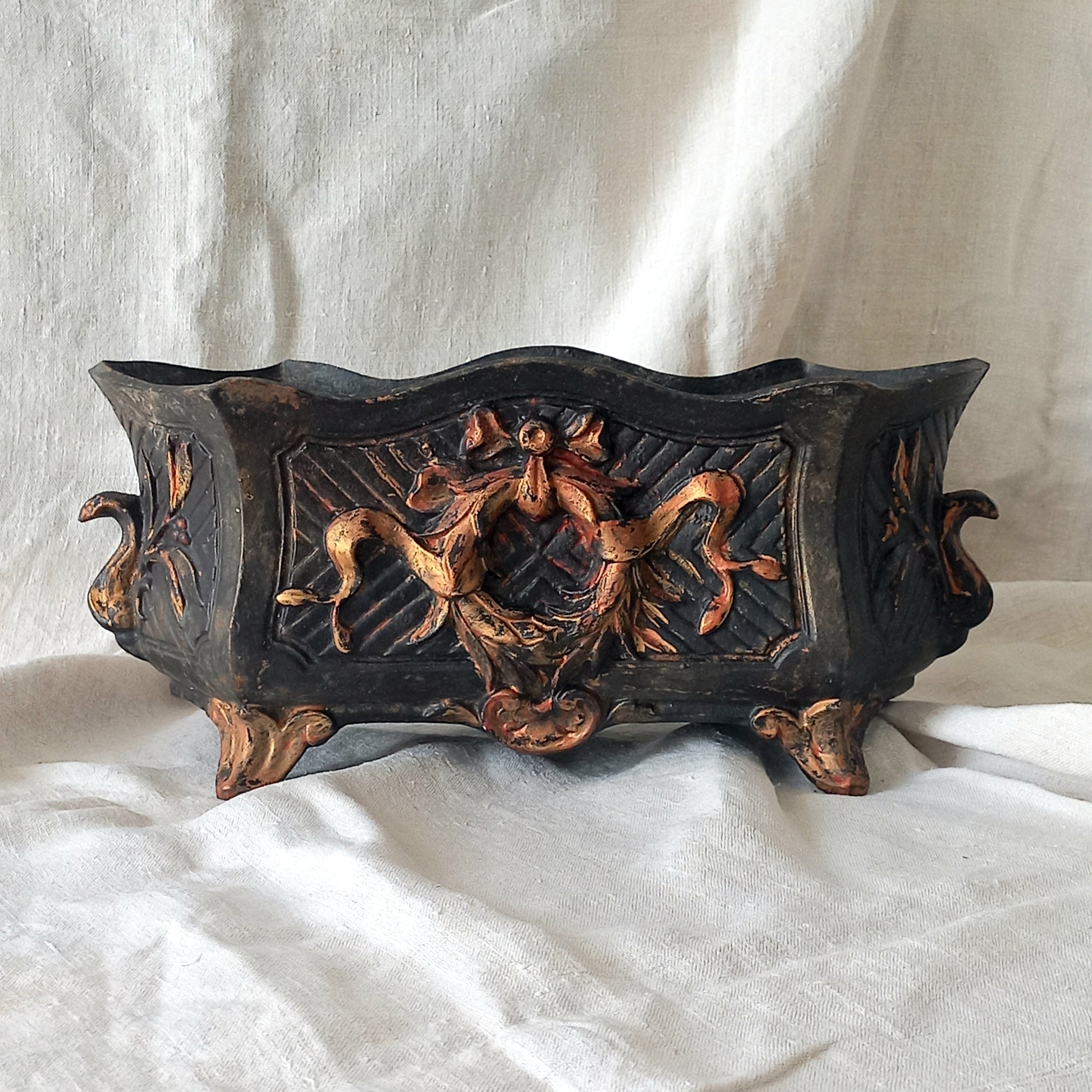 A stunning French antique decorative cast iron planter with patina of age suitable for both interior and exterior use - we rarely come across them these days so this was an exciting find.

The planter is in a striking and wonderfully aged black colour with gold coloured detailing in relief - there's some great paint chipping off areas of the gold paint showing small areas of red beneath, and also chipping from the black paint showing rusty patina, all of which add to the antique character of this beautiful 