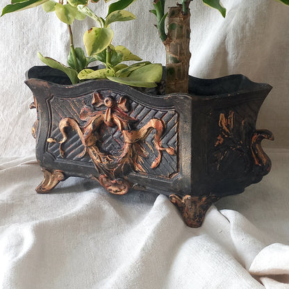 A stunning French antique decorative cast iron planter with patina of age suitable for both interior and exterior use - we rarely come across them these days so this was an exciting find.

The planter is in a striking and wonderfully aged black colour with gold coloured detailing in relief - there's some great paint chipping off areas of the gold paint showing small areas of red beneath, and also chipping from the black paint showing rusty patina, all of which add to the antique character of this beautiful 