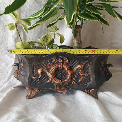 A stunning French antique decorative cast iron planter with patina of age suitable for both interior and exterior use - we rarely come across them these days so this was an exciting find.

The planter is in a striking and wonderfully aged black colour with gold coloured detailing in relief - there's some great paint chipping off areas of the gold paint showing small areas of red beneath, and also chipping from the black paint showing rusty patina, all of which add to the antique character of this beautiful 