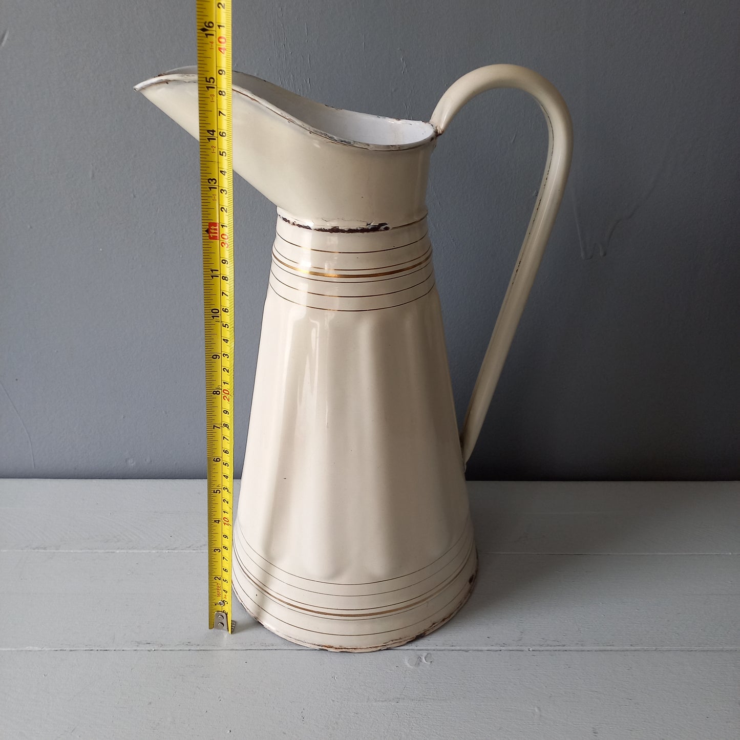 Large antique enamel metal pitcher in cream color with gold trim from France
