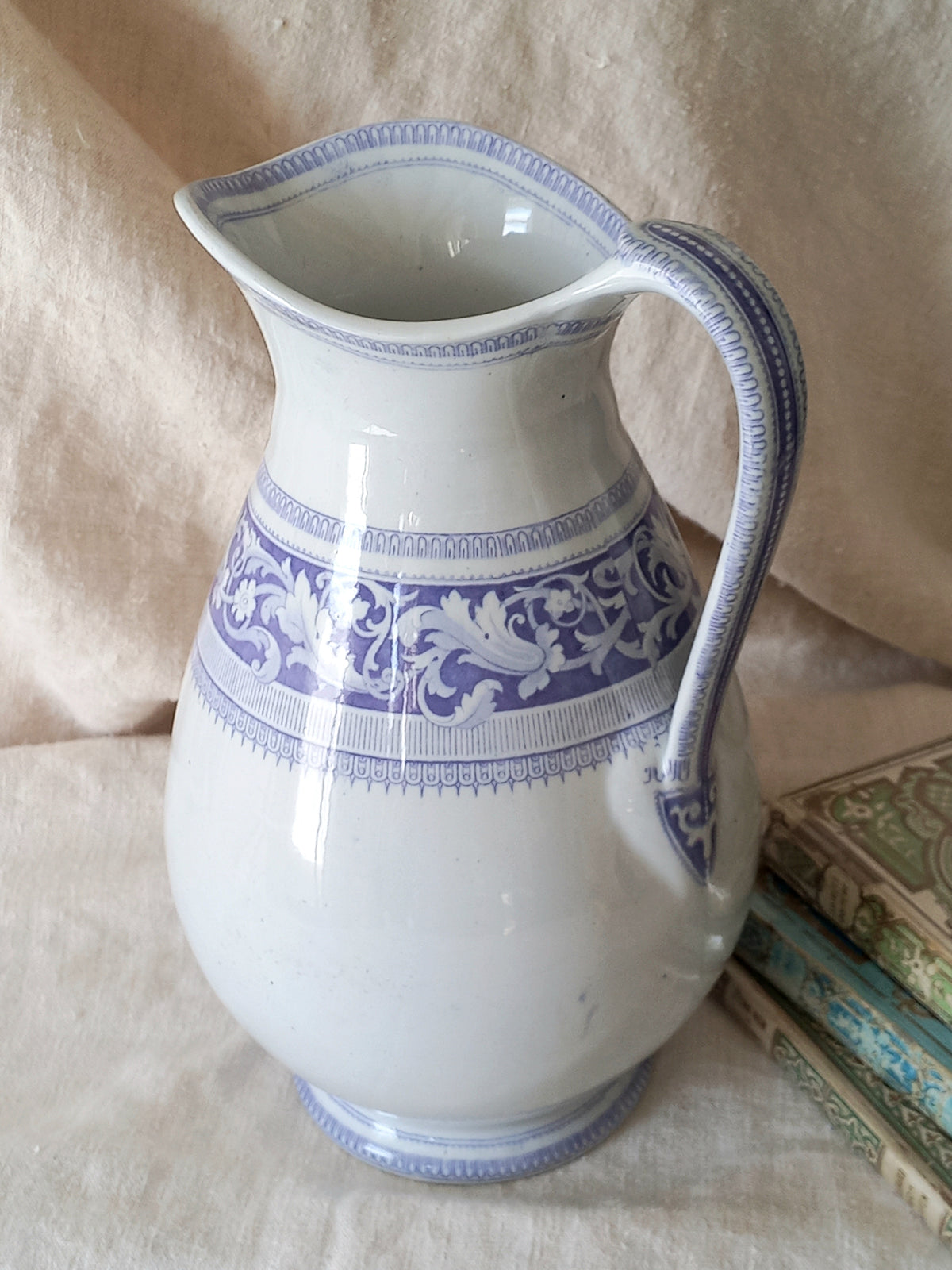 antique ironstone pitcher in white with a rare lavender colour decorative pattern in a decorative setting.