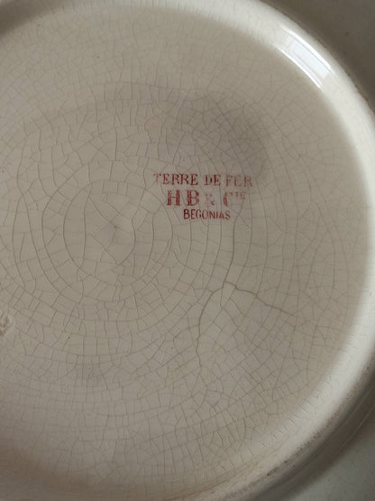 A large French ironstone bowl with deep pink floral pattern on a creamy white base. This antique piece has aged naturally over time, showing fine crazing, tea-staining, and small imperfections that reflect its long history.