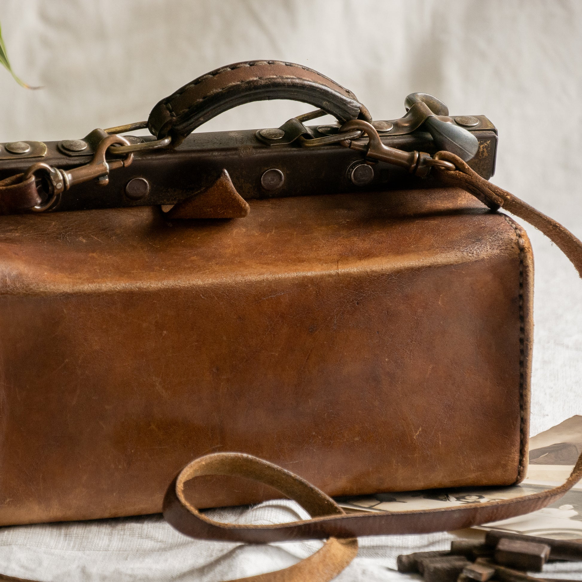 A French vintage leather shoulder/hand bag that's both practical and perfect as a prop or decorative piece in your interior, a beautifully aged piece with just enough patina of age to give it that authentic character. We have polished the distressed leather and thoroughly cleaned the bag both inside and out.