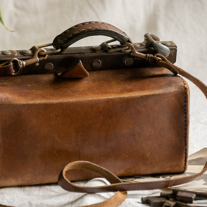 A French vintage leather shoulder/hand bag that's both practical and perfect as a prop or decorative piece in your interior, a beautifully aged piece with just enough patina of age to give it that authentic character. We have polished the distressed leather and thoroughly cleaned the bag both inside and out.