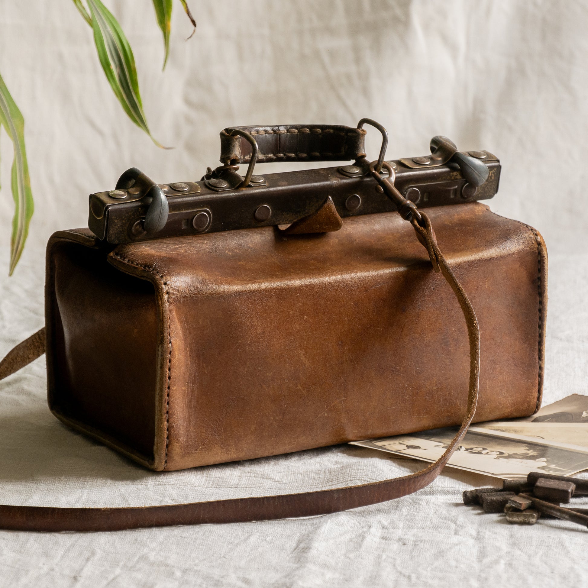 A French vintage leather shoulder/hand bag that's both practical and perfect as a prop or decorative piece in your interior, a beautifully aged piece with just enough patina of age to give it that authentic character. We have polished the distressed leather and thoroughly cleaned the bag both inside and out.
