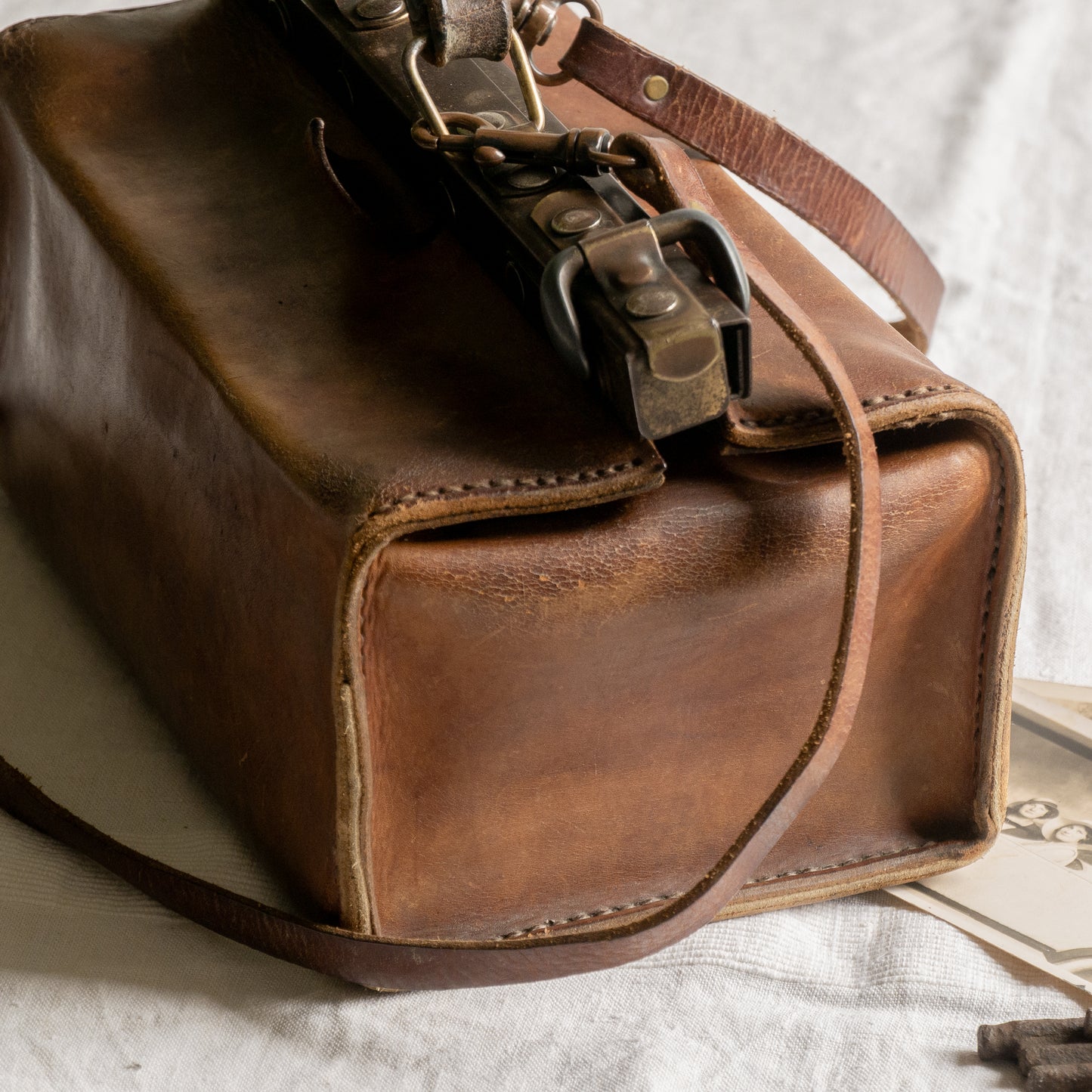 A French vintage leather shoulder/hand bag that's both practical and perfect as a prop or decorative piece in your interior, a beautifully aged piece with just enough patina of age to give it that authentic character. We have polished the distressed leather and thoroughly cleaned the bag both inside and out.