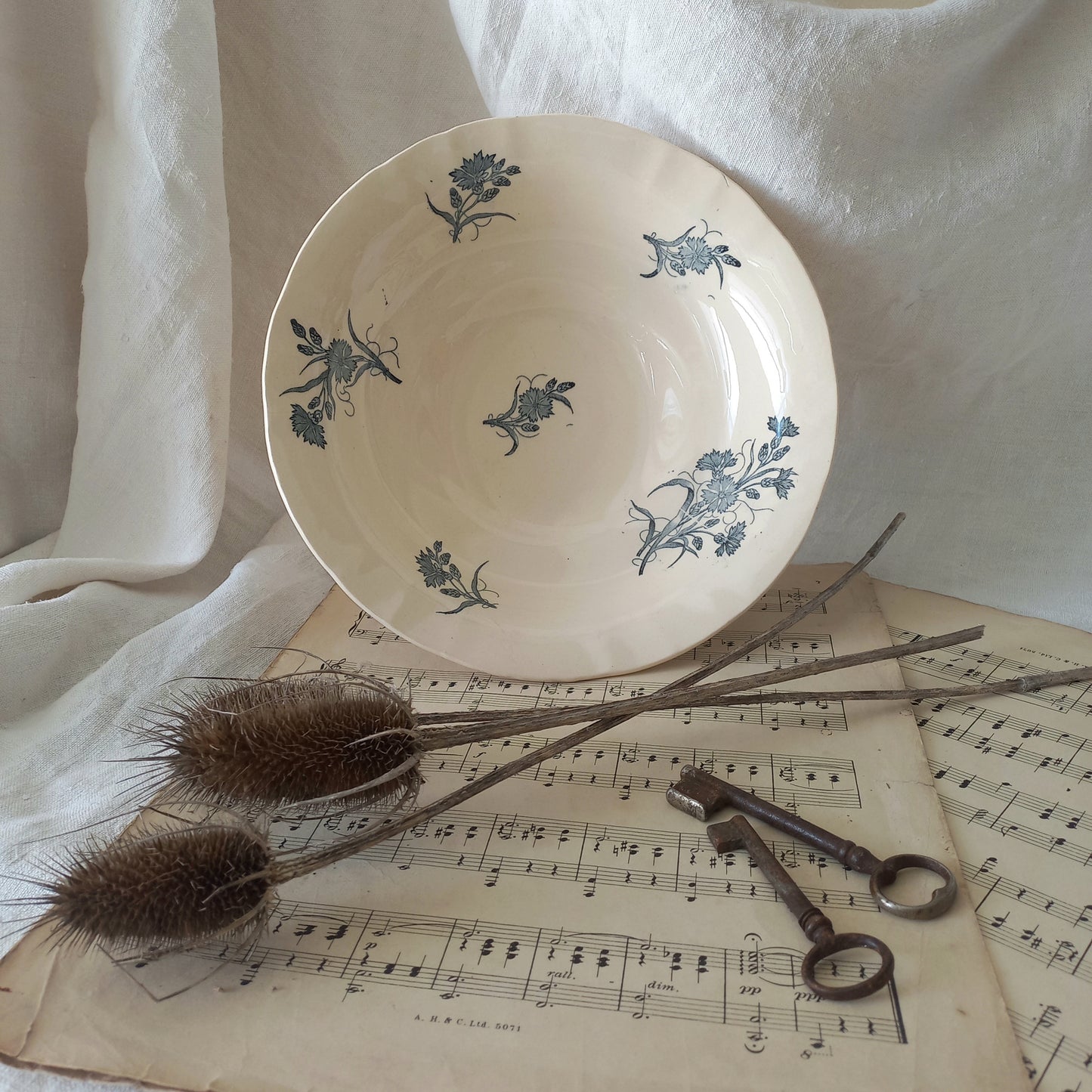 A beautiful antique compote or footed bowl by French manufacturer Longchamp. The main colour is a warm cream/white with blue floral transferware pattern.