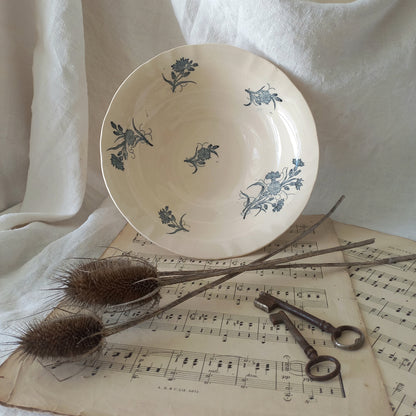 A beautiful antique compote or footed bowl by French manufacturer Longchamp. The main colour is a warm cream/white with blue floral transferware pattern.