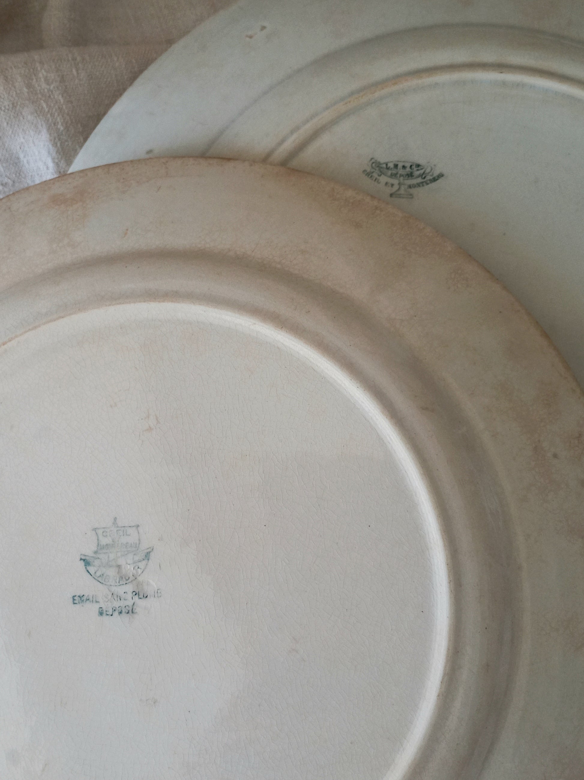 Close-up of an antique plate with a logo and text on a beige background