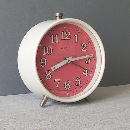 A wonderful vintage alarm clock in an eye-catching white and pink color scheme. This old clock is in working condition including the alarm and has a nice soothing ticking sound too. A great piece of European history from the former country of Czechoslovakia.