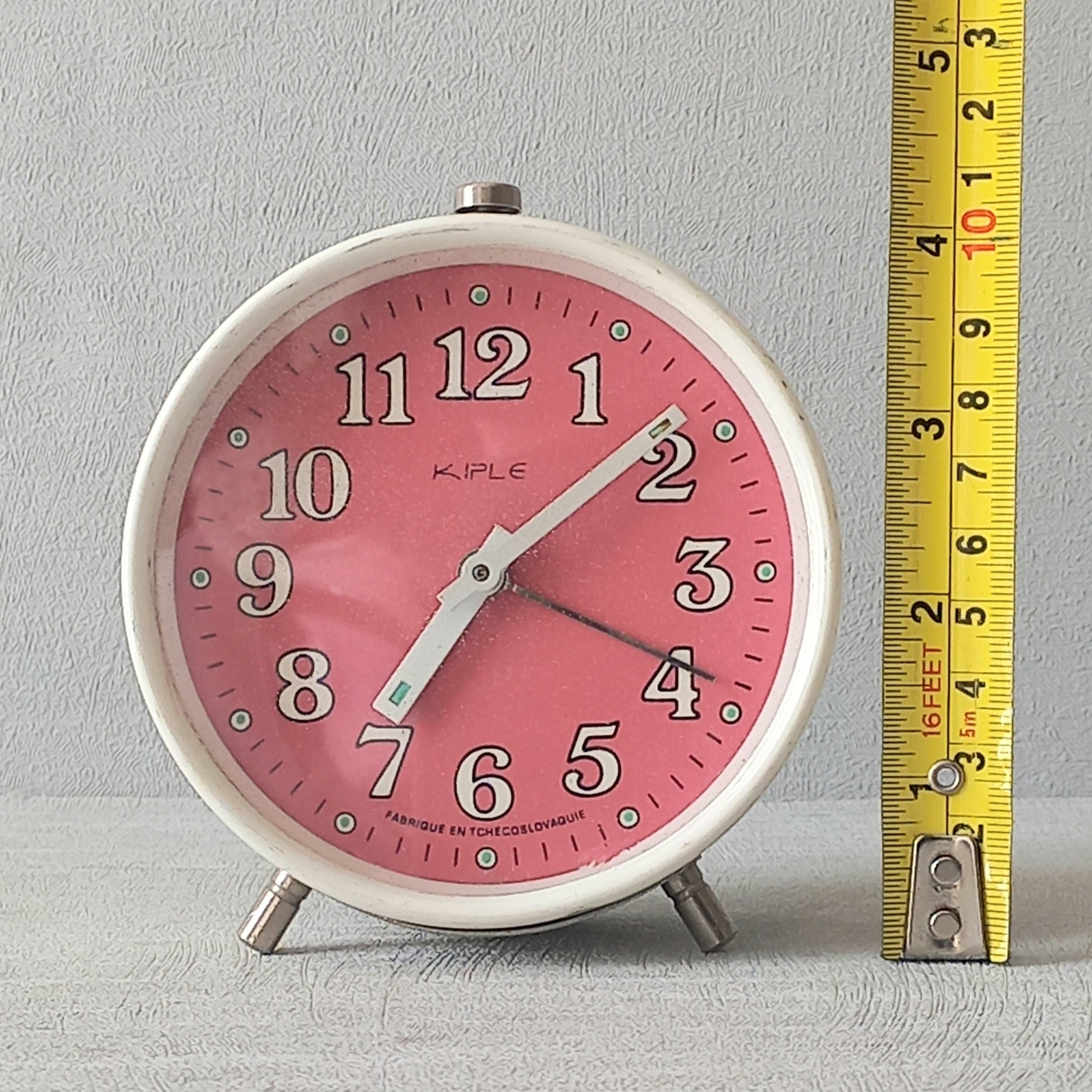 A wonderful vintage alarm clock in an eye-catching white and pink color scheme. This old clock is in working condition including the alarm and has a nice soothing ticking sound too. A great piece of European history from the former country of Czechoslovakia.