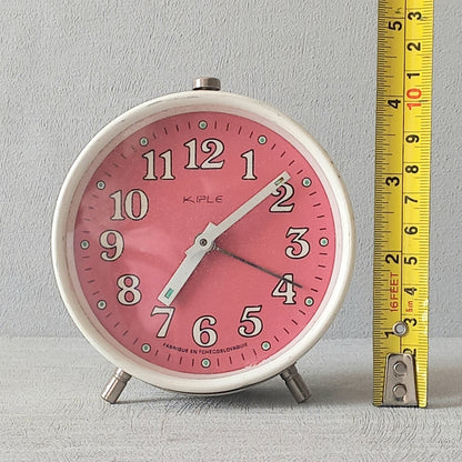 A wonderful vintage alarm clock in an eye-catching white and pink color scheme. This old clock is in working condition including the alarm and has a nice soothing ticking sound too. A great piece of European history from the former country of Czechoslovakia.