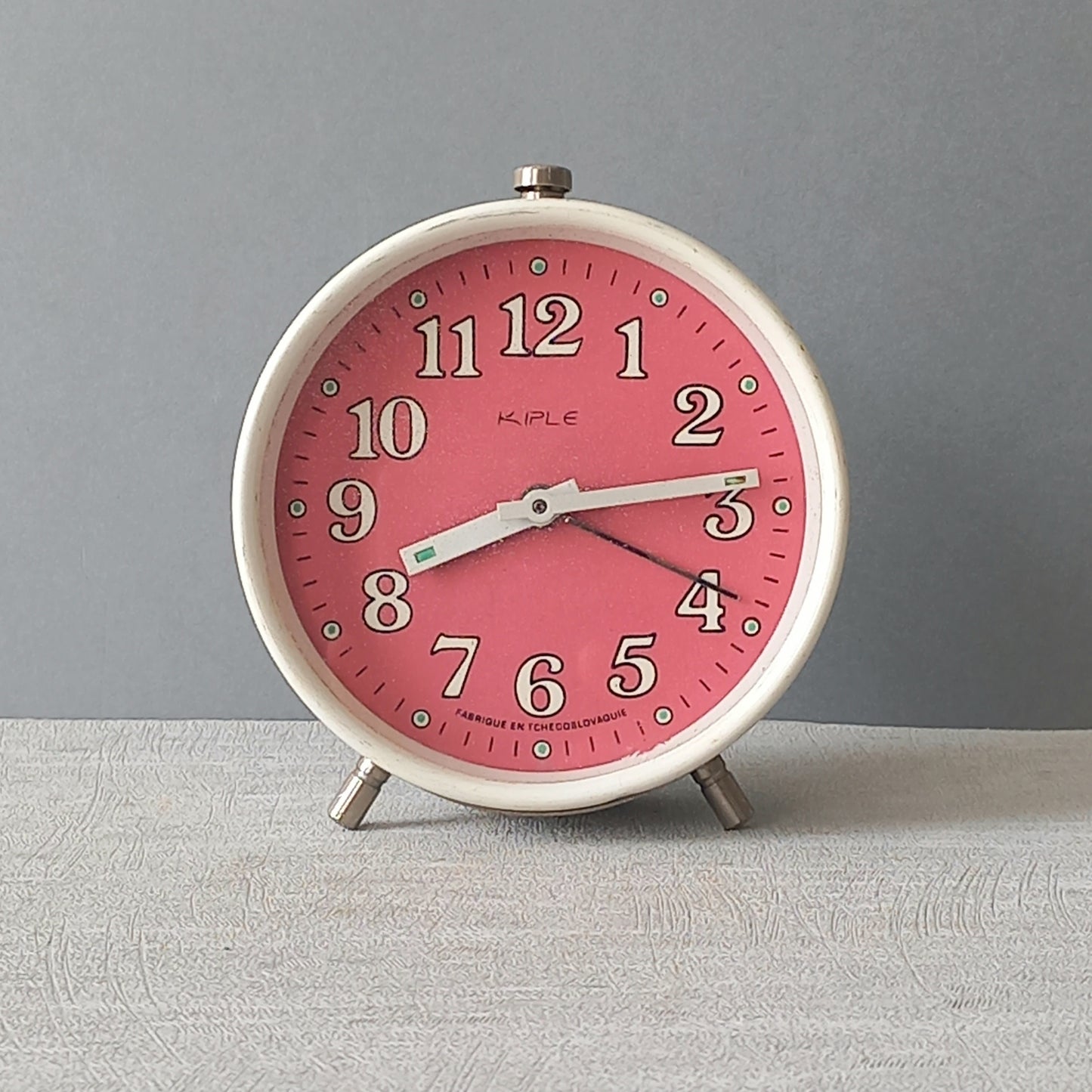 A wonderful vintage alarm clock in an eye-catching white and pink color scheme. This old clock is in working condition including the alarm and has a nice soothing ticking sound too. A great piece of European history from the former country of Czechoslovakia

In summary, a nice vintage alarm clock!