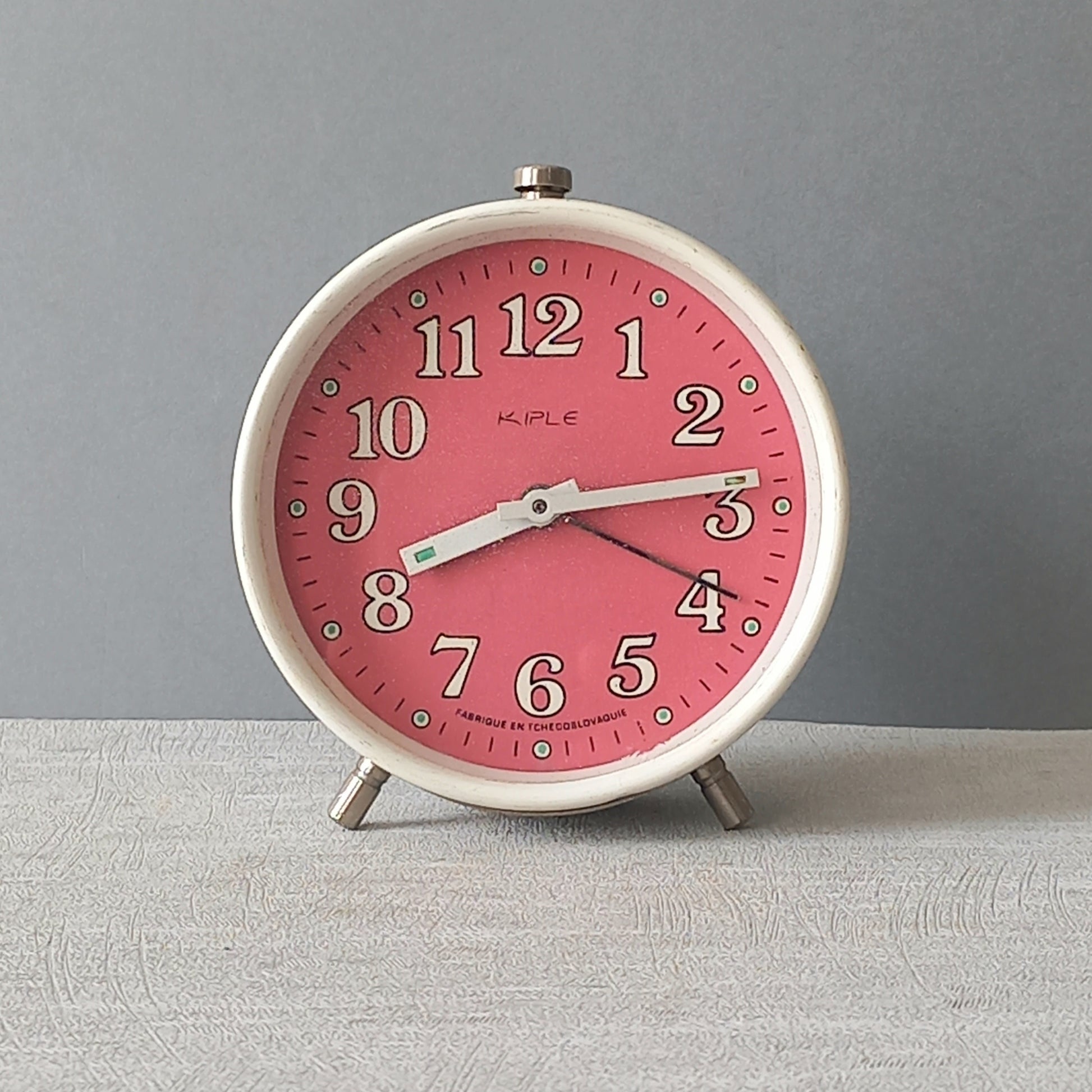 A wonderful vintage alarm clock in an eye-catching white and pink color scheme. This old clock is in working condition including the alarm and has a nice soothing ticking sound too. A great piece of European history from the former country of Czechoslovakia

In summary, a nice vintage alarm clock!