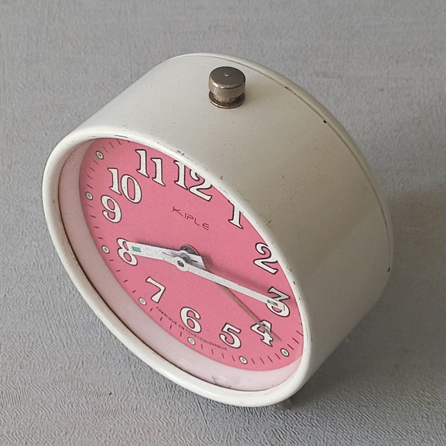A wonderful vintage alarm clock in an eye-catching white and pink color scheme. This old clock is in working condition including the alarm and has a nice soothing ticking sound too. A great piece of European history from the former country of Czechoslovakia.