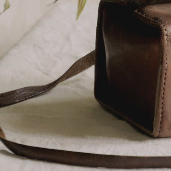 A French vintage leather shoulder/hand bag that's both practical and perfect as a prop or decorative piece in your interior, a beautifully aged piece with just enough patina of age to give it that authentic character. We have polished the distressed leather and thoroughly cleaned the bag both inside and out.