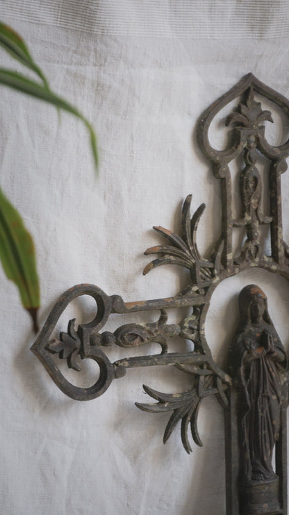 A large French antique crucifix in cast or wrought iron, featuring a figure of the Madonna at its center. Likely once part of a larger architectural structure, this rare piece carries visible signs of age and long exposure to the elements.