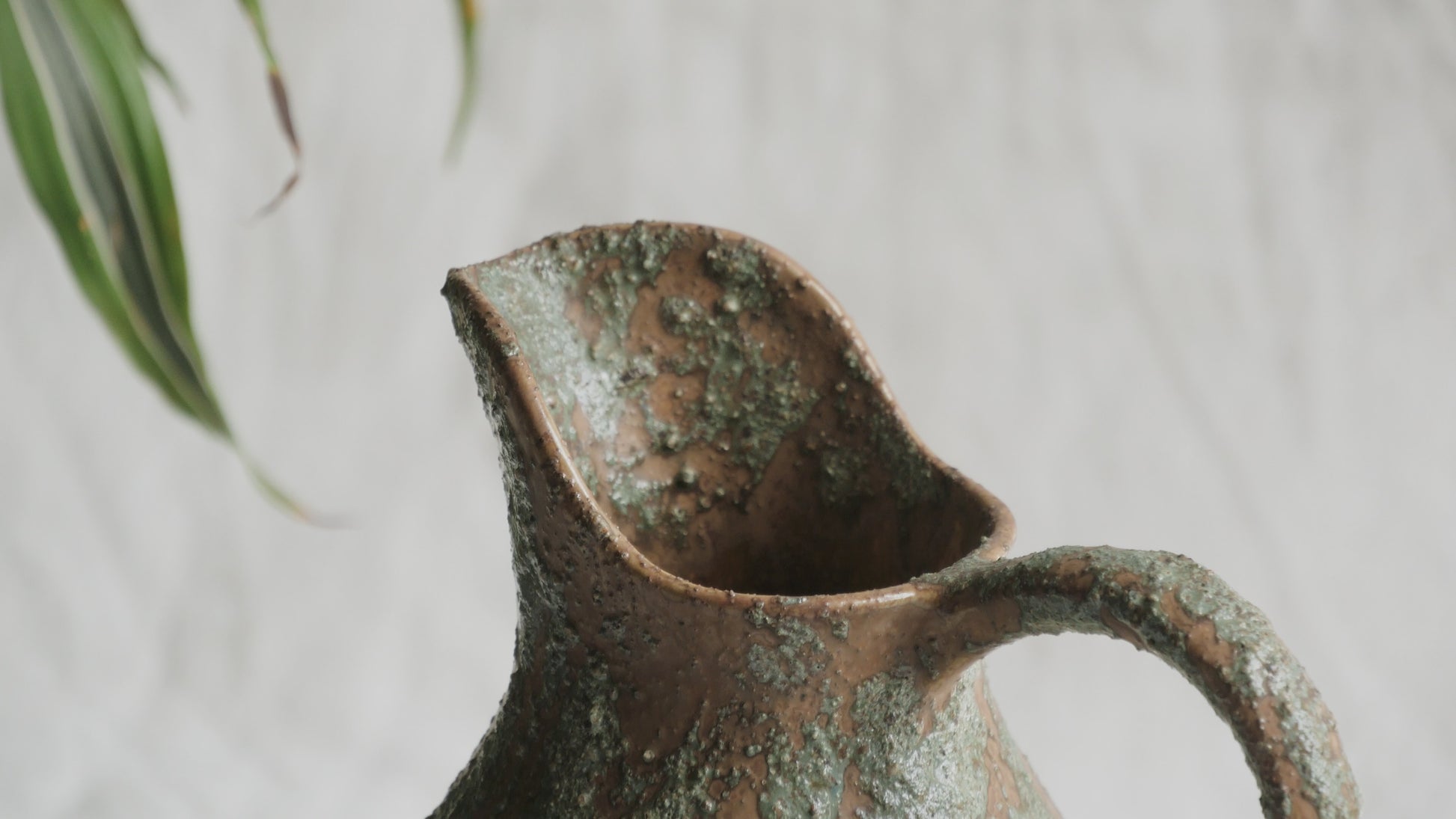 An artisan-made vintage pottery pitcher or jug that purchased in south west France. This piece is wonderful in its earthy tones of brown with a green pattern in relief all over the pitcher and would make a great piece of home decor or addition to a pottery/stoneware collection.