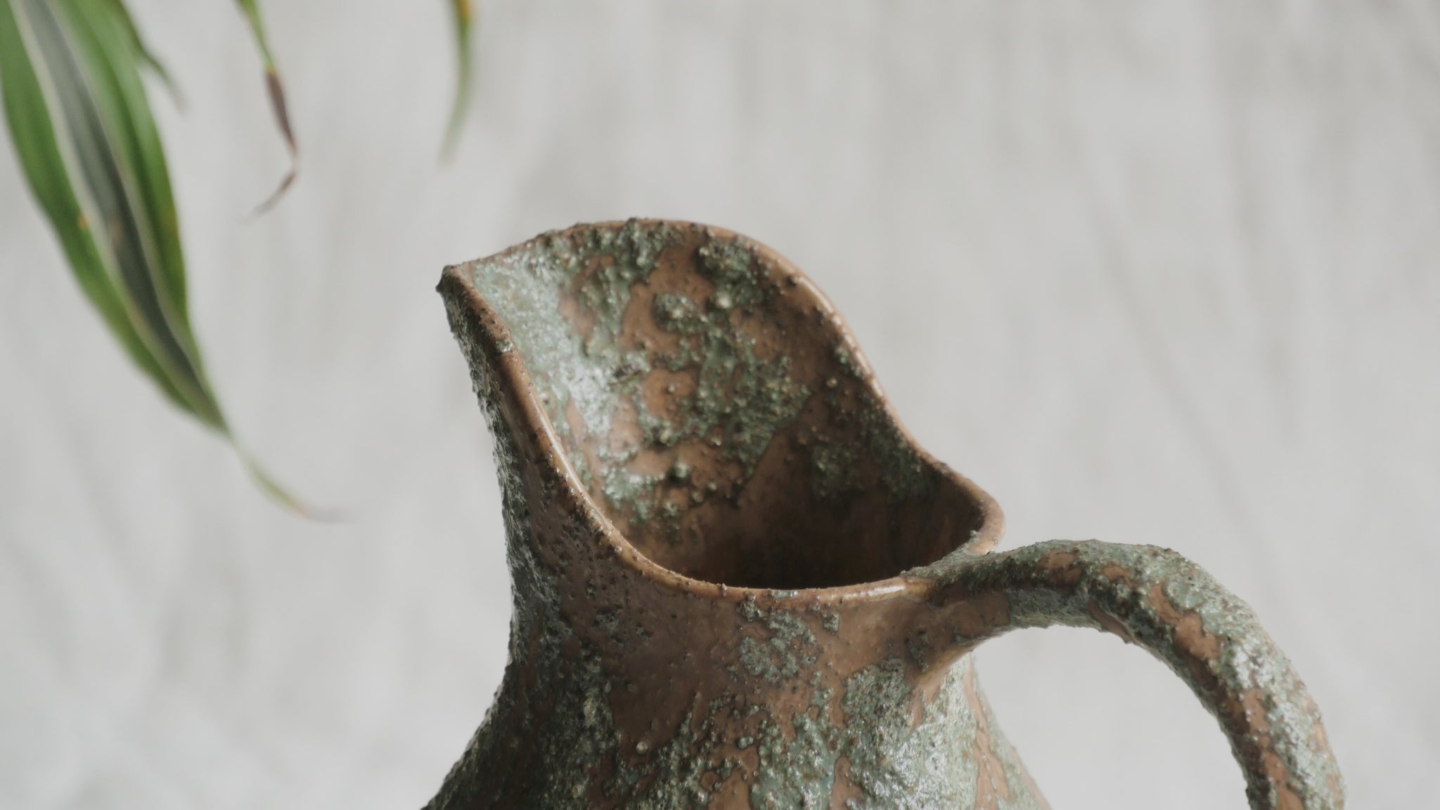 An artisan-made vintage pottery pitcher or jug that purchased in south west France. This piece is wonderful in its earthy tones of brown with a green pattern in relief all over the pitcher and would make a great piece of home decor or addition to a pottery/stoneware collection.
