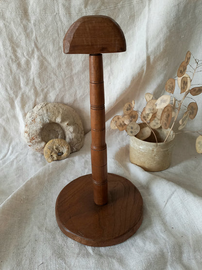 vintage wooden hat stand on a textured white fabric background