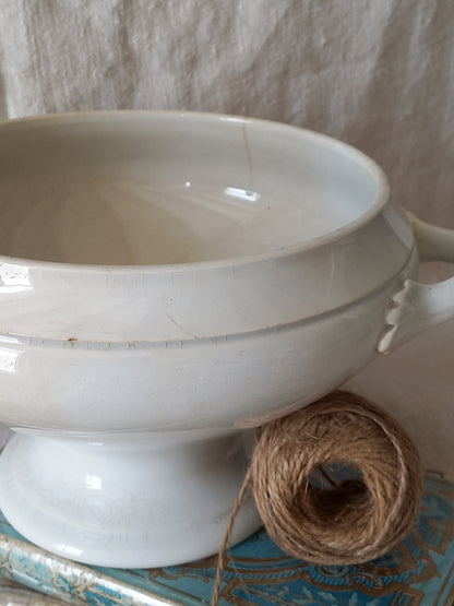 White ceramic bowl with a ball of twine on a textured surface