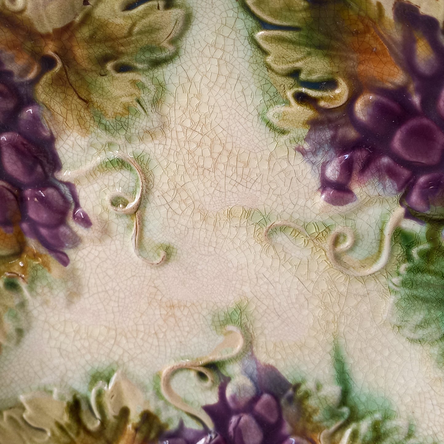 Small and beautiful French antique crazed majolica plate with a wonderful colour scheme depicting dark purple grapes and green foliage; this wonderful old plate will make an excellent addition to a collection or as a stand-alone display piece.
