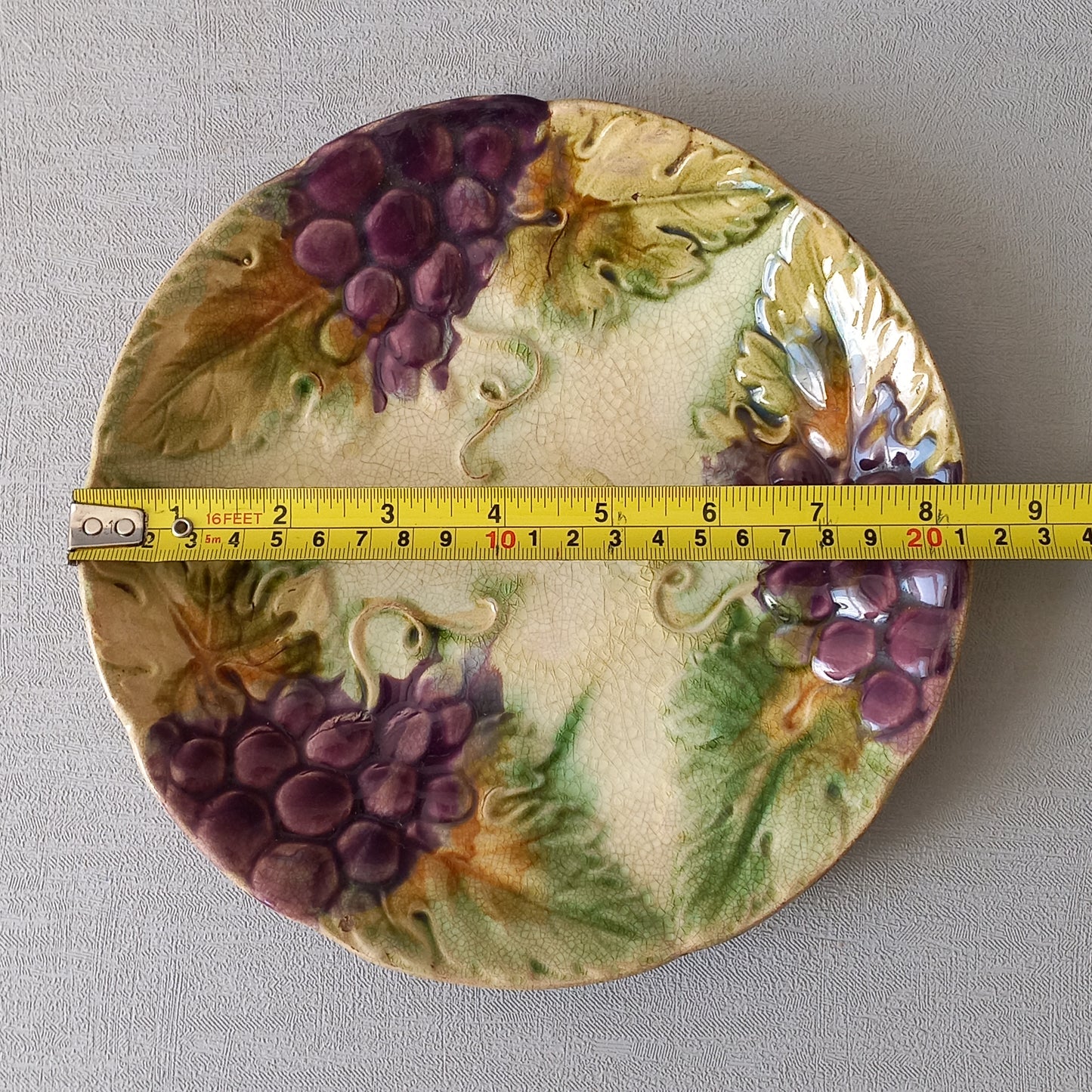 Small and beautiful French antique crazed majolica plate with a wonderful colour scheme depicting dark purple grapes and green foliage; this wonderful old plate will make an excellent addition to a collection or as a stand-alone display piece.