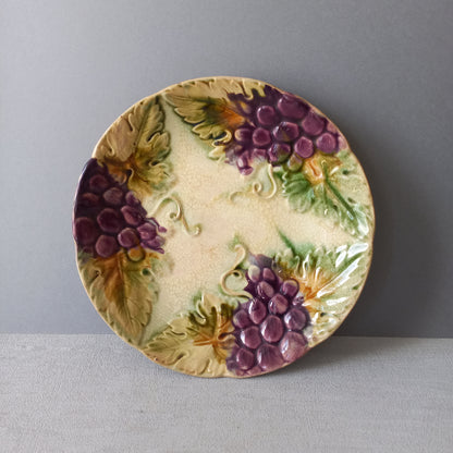 Small and beautiful French antique crazed majolica plate with a wonderful colour scheme depicting dark purple grapes and green foliage; this wonderful old plate will make an excellent addition to a collection or as a stand-alone display piece.