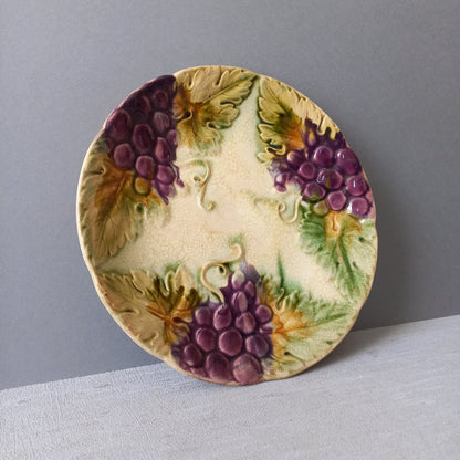 Small and beautiful French antique crazed majolica plate with a wonderful colour scheme depicting dark purple grapes and green foliage; this wonderful old plate will make an excellent addition to a collection or as a stand-alone display piece.