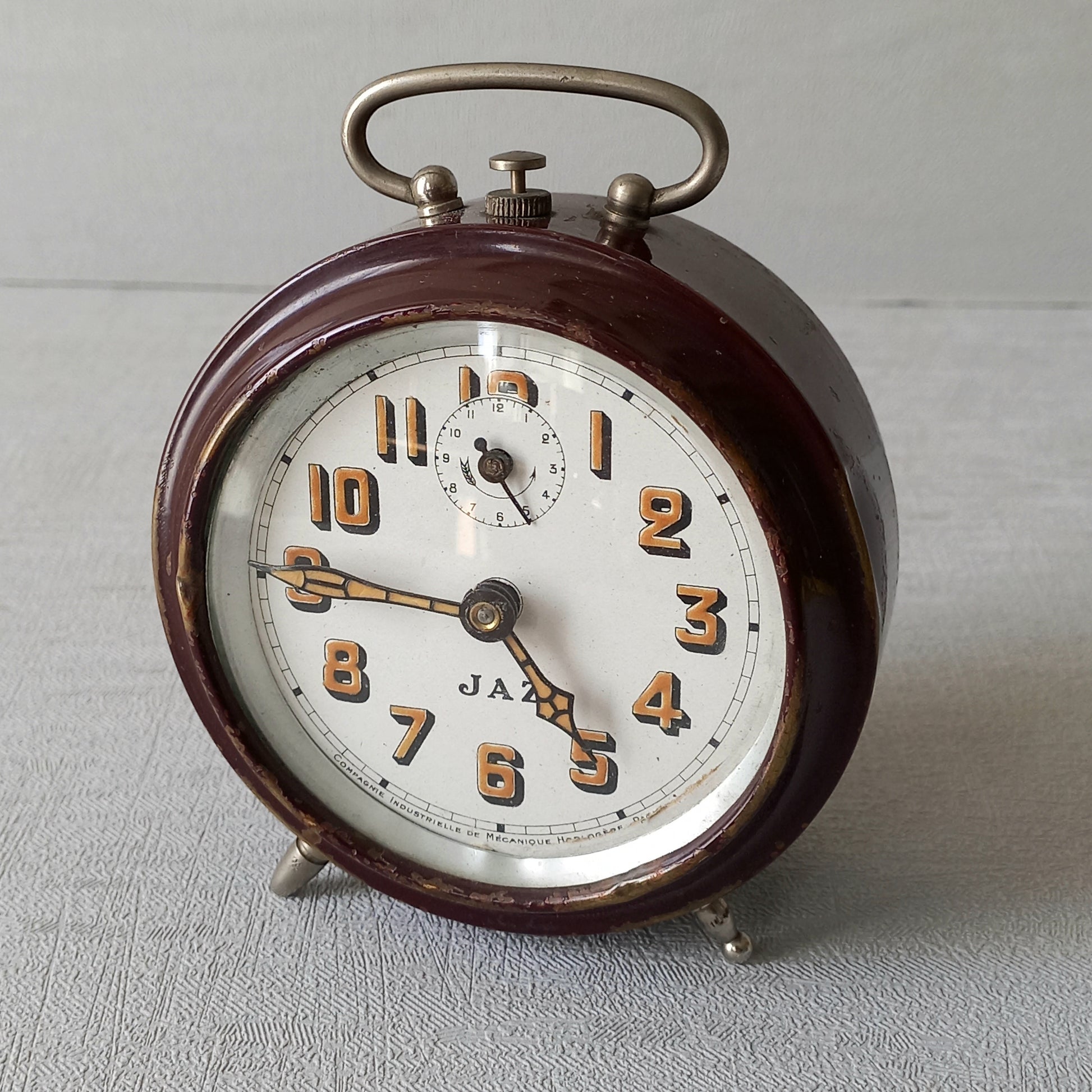 A handsome little vintage alarm clock by premier French manufacturer, Jaz.

This wonderful little clock is in semi-working condition including the alarm, although I should note that being an old time piece dating from the pre-1940 period he's temperamental and sometimes will just stop working, although all that's needed is a gentle shake from side to side and he will once more begin to tick - sometimes you might have to repeat this and have patience with him.