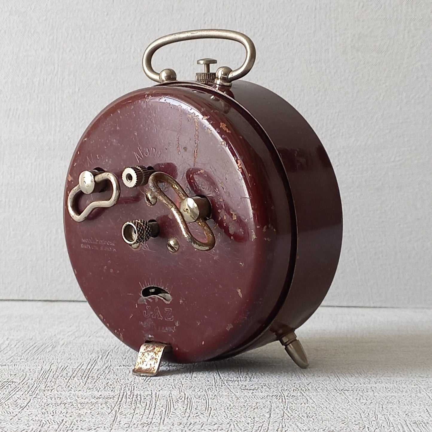 A handsome little vintage alarm clock by premier French manufacturer, Jaz.

This wonderful little clock is in semi-working condition including the alarm, although I should note that being an old time piece dating from the pre-1940 period he's temperamental and sometimes will just stop working, although all that's needed is a gentle shake from side to side and he will once more begin to tick - sometimes you might have to repeat this and have patience with him.