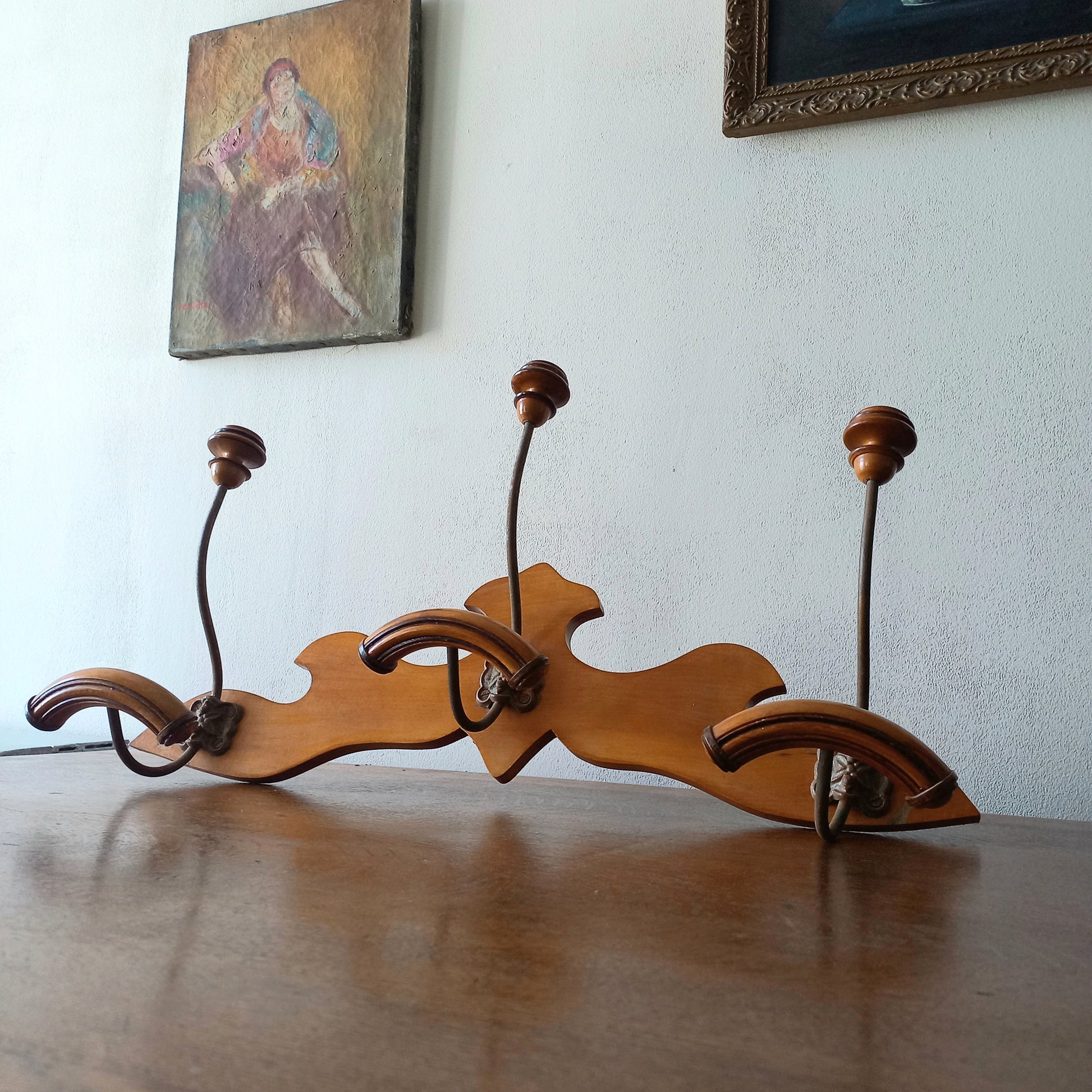 A stunning French vintage coat and hat rack with a decorative wooden wall-mounted rack holding 3 metal hooks, each hook having 2 turned wooden pegs for a hat and coat.

In summary a decorative and practical piece of vintage wall decor for any interior.