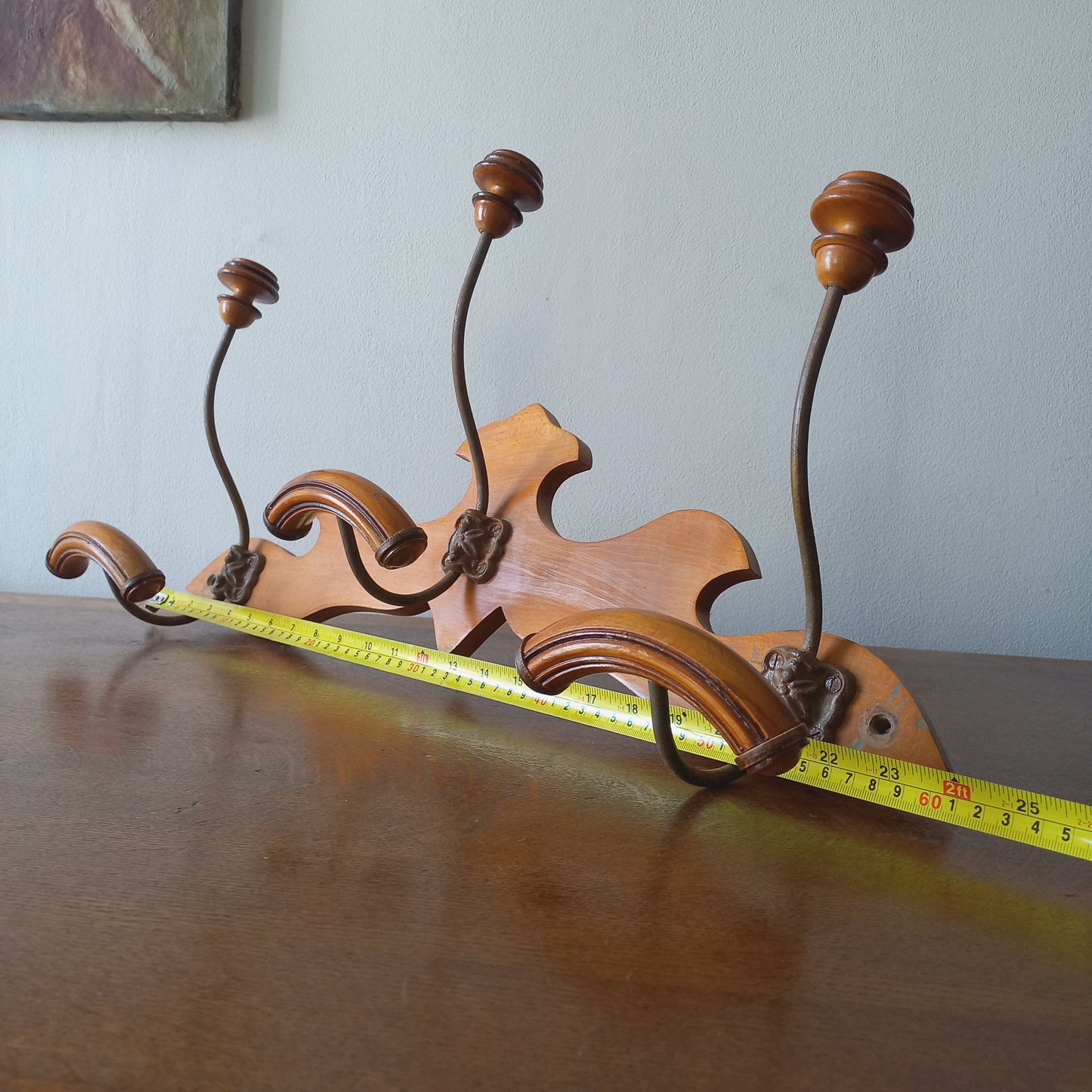 A stunning French vintage coat and hat rack with a decorative wooden wall-mounted rack holding 3 metal hooks, each hook having 2 turned wooden pegs for a hat and coat.

In summary a decorative and practical piece of vintage wall decor for any interior.