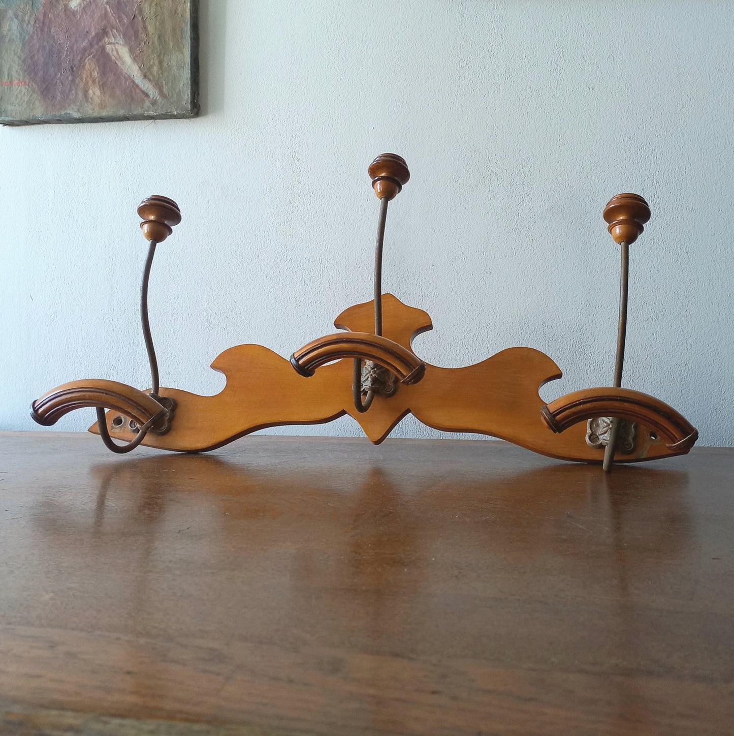 A stunning French vintage coat and hat rack with a decorative wooden wall-mounted rack holding 3 metal hooks, each hook having 2 turned wooden pegs for a hat and coat.

In summary a decorative and practical piece of vintage wall decor for any interior.