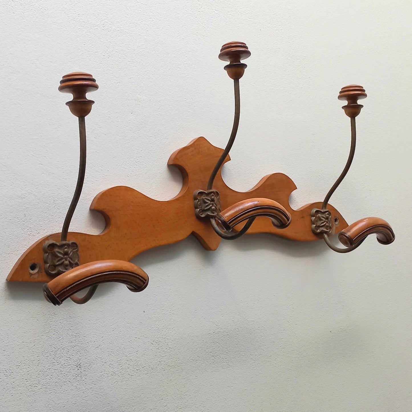 A stunning French vintage coat and hat rack with a decorative wooden wall-mounted rack holding 3 metal hooks, each hook having 2 turned wooden pegs for a hat and coat.

In summary a decorative and practical piece of vintage wall decor for any interior.