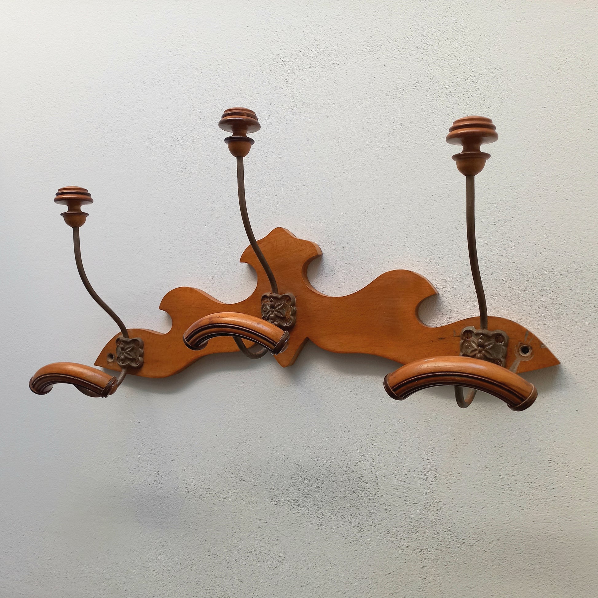 A stunning French vintage coat and hat rack with a decorative wooden wall-mounted rack holding 3 metal hooks, each hook having 2 turned wooden pegs for a hat and coat.

In summary a decorative and practical piece of vintage wall decor for any interior.