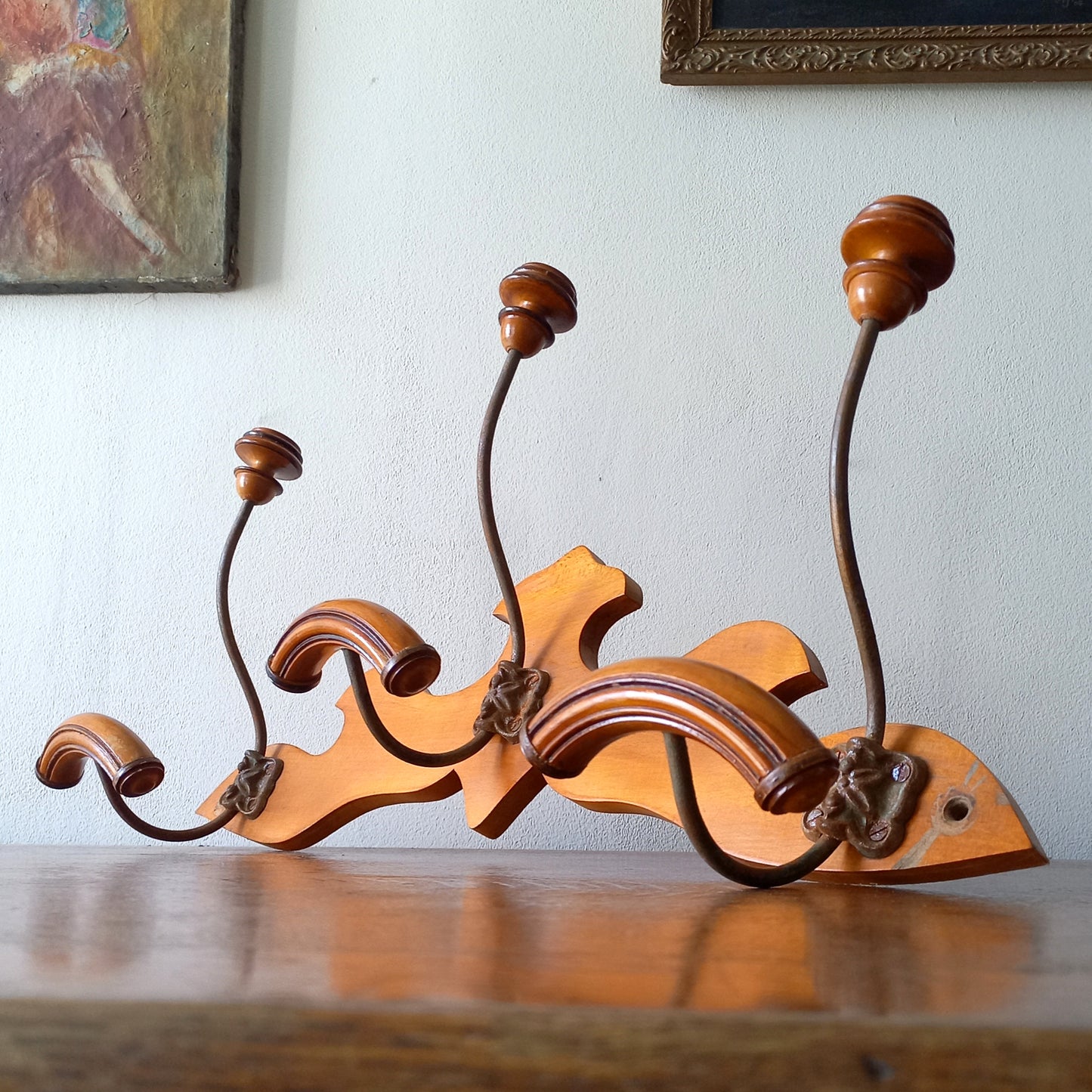A stunning French vintage coat and hat rack with a decorative wooden wall-mounted rack holding 3 metal hooks, each hook having 2 turned wooden pegs for a hat and coat.

In summary a decorative and practical piece of vintage wall decor for any interior.