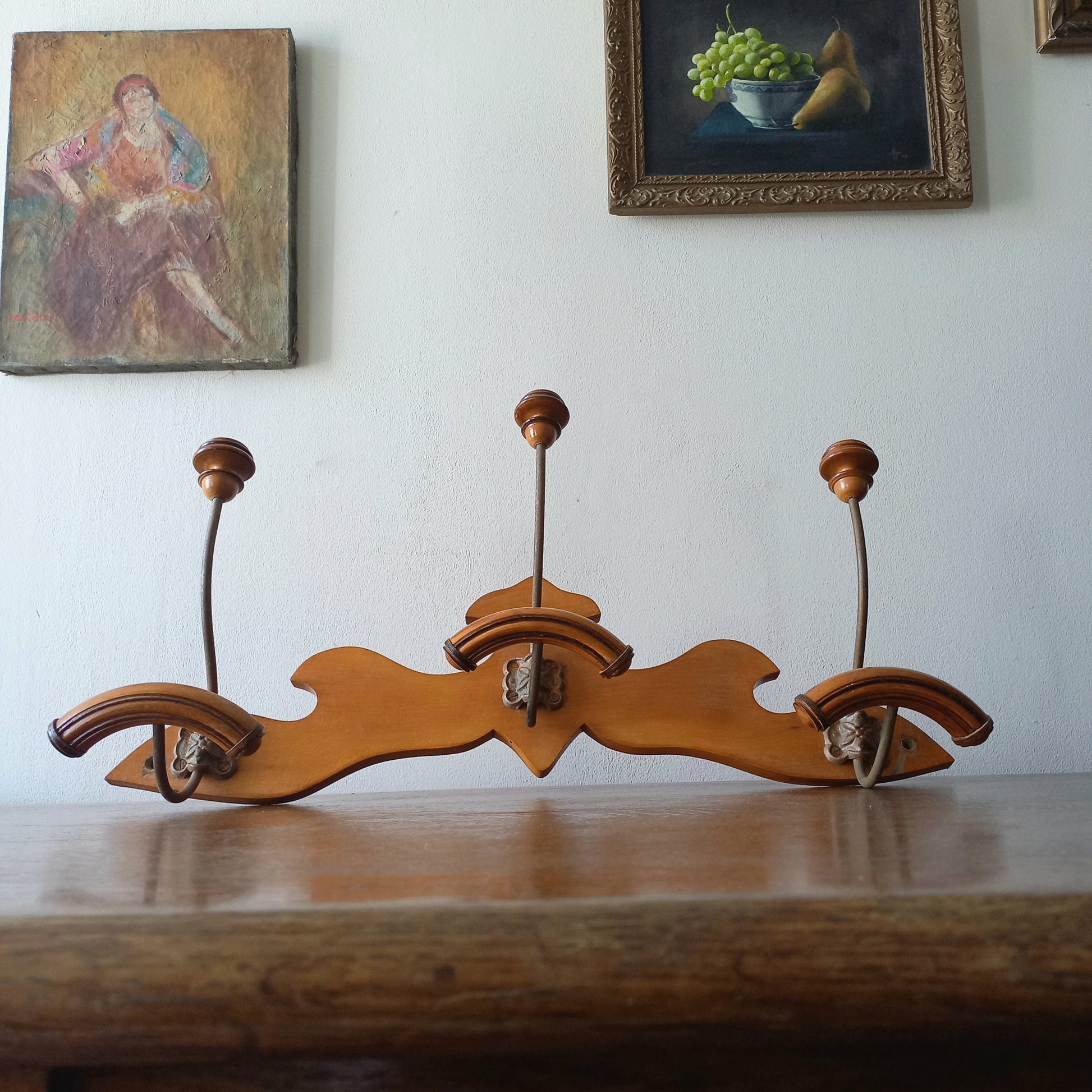 A stunning French vintage coat and hat rack with a decorative wooden wall-mounted rack holding 3 metal hooks, each hook having 2 turned wooden pegs for a hat and coat.

In summary a decorative and practical piece of vintage wall decor for any interior.