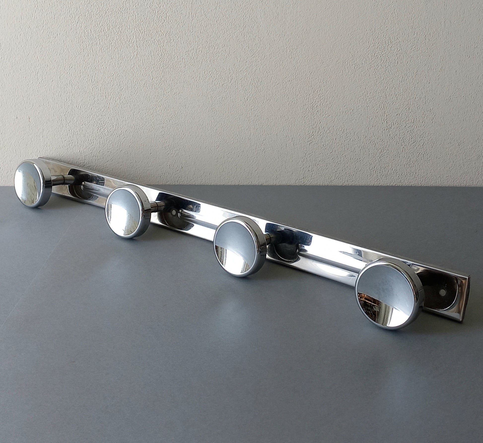 A stylish French vintage 4 peg metal coat rack with a polished finish, a great piece of practical wall decor for your home.