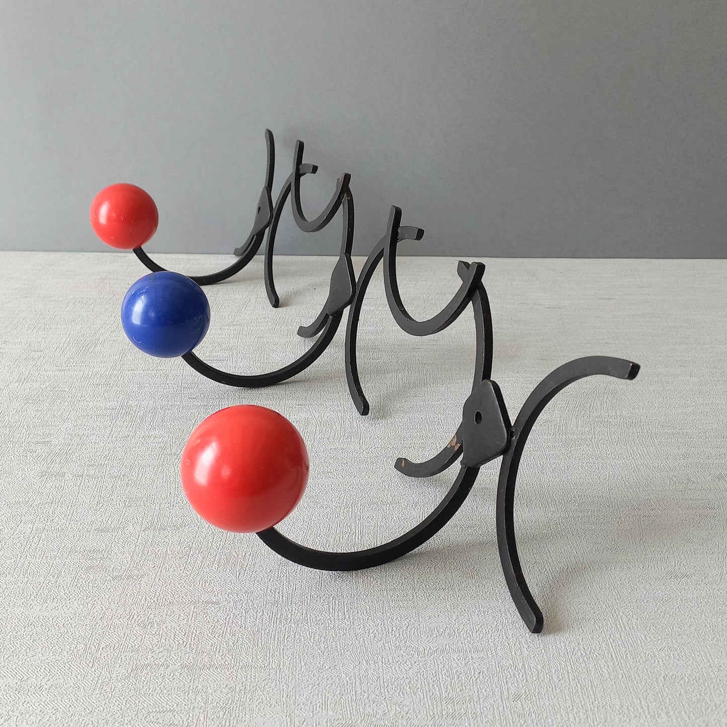 An original French vintage mid-century 'atomic' coat rack, a rare find these days and a wonderful piece of practical home decor. The black frame-work that holds the coloured pegs/balls is made from strong cast iron and there are two screw holes so that you can immediately fix the coat rack to your wall.