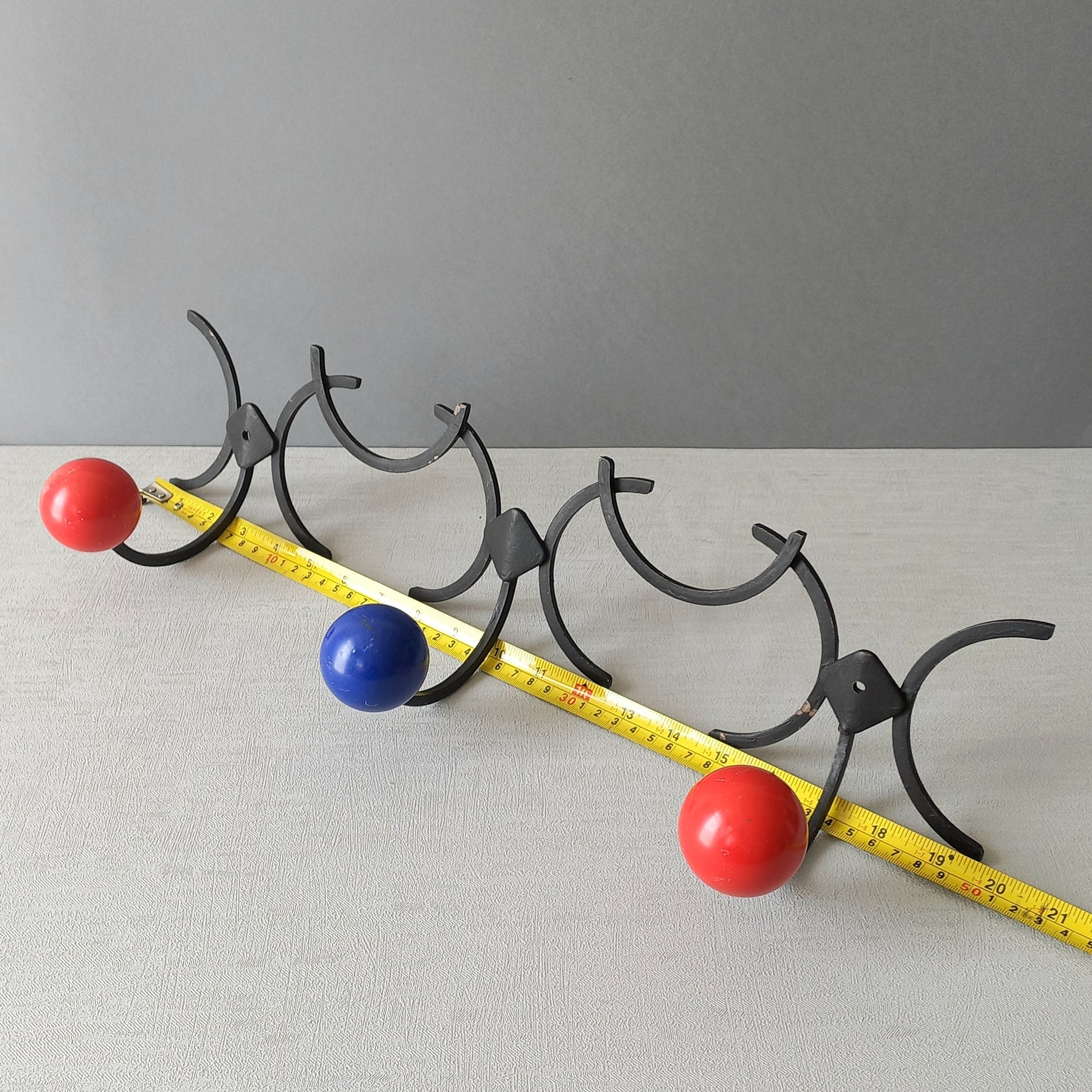 An original French vintage mid-century 'atomic' coat rack, a rare find these days and a wonderful piece of practical home decor. The black frame-work that holds the coloured pegs/balls is made from strong cast iron and there are two screw holes so that you can immediately fix the coat rack to your wall.