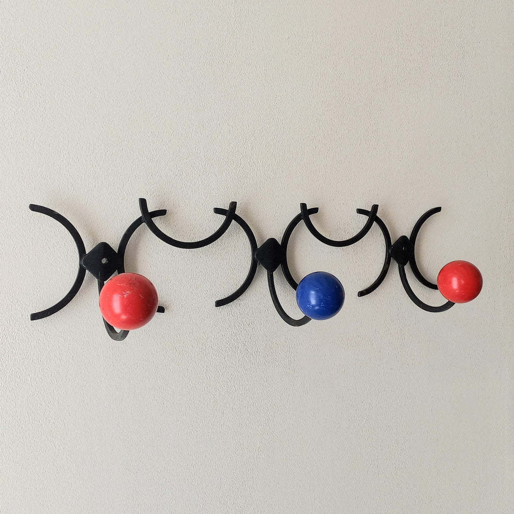 An original French vintage mid-century 'atomic' coat rack, a rare find these days and a wonderful piece of practical home decor. The black frame-work that holds the coloured pegs/balls is made from strong cast iron and there are two screw holes so that you can immediately fix the coat rack to your wall.
