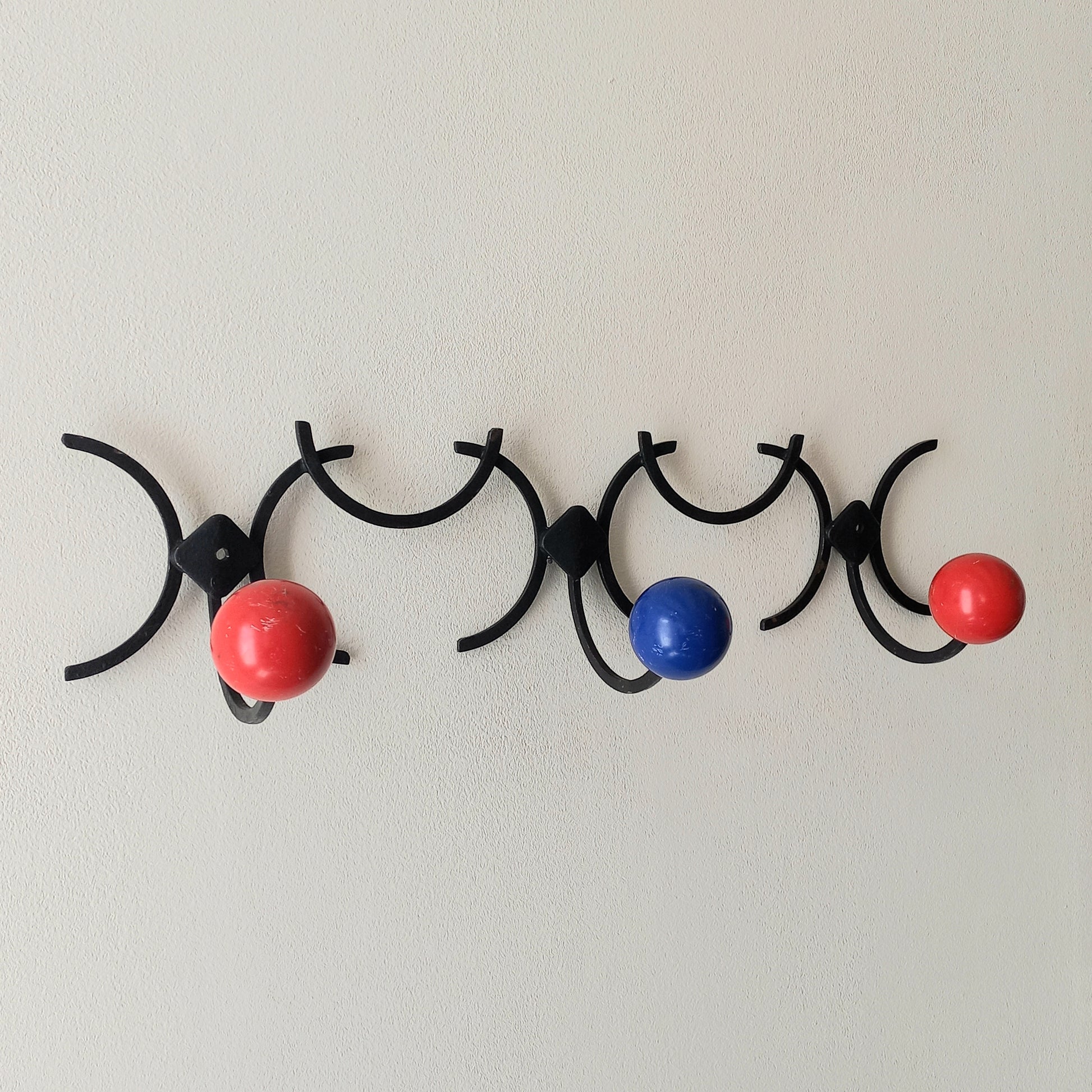 An original French vintage mid-century 'atomic' coat rack, a rare find these days and a wonderful piece of practical home decor. The black frame-work that holds the coloured pegs/balls is made from strong cast iron and there are two screw holes so that you can immediately fix the coat rack to your wall.