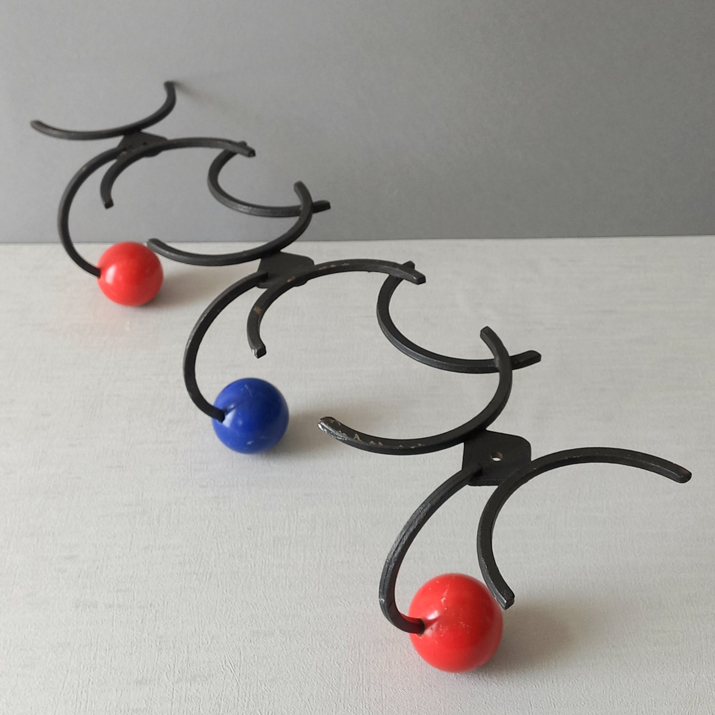 An original French vintage mid-century 'atomic' coat rack, a rare find these days and a wonderful piece of practical home decor. The black frame-work that holds the coloured pegs/balls is made from strong cast iron and there are two screw holes so that you can immediately fix the coat rack to your wall.