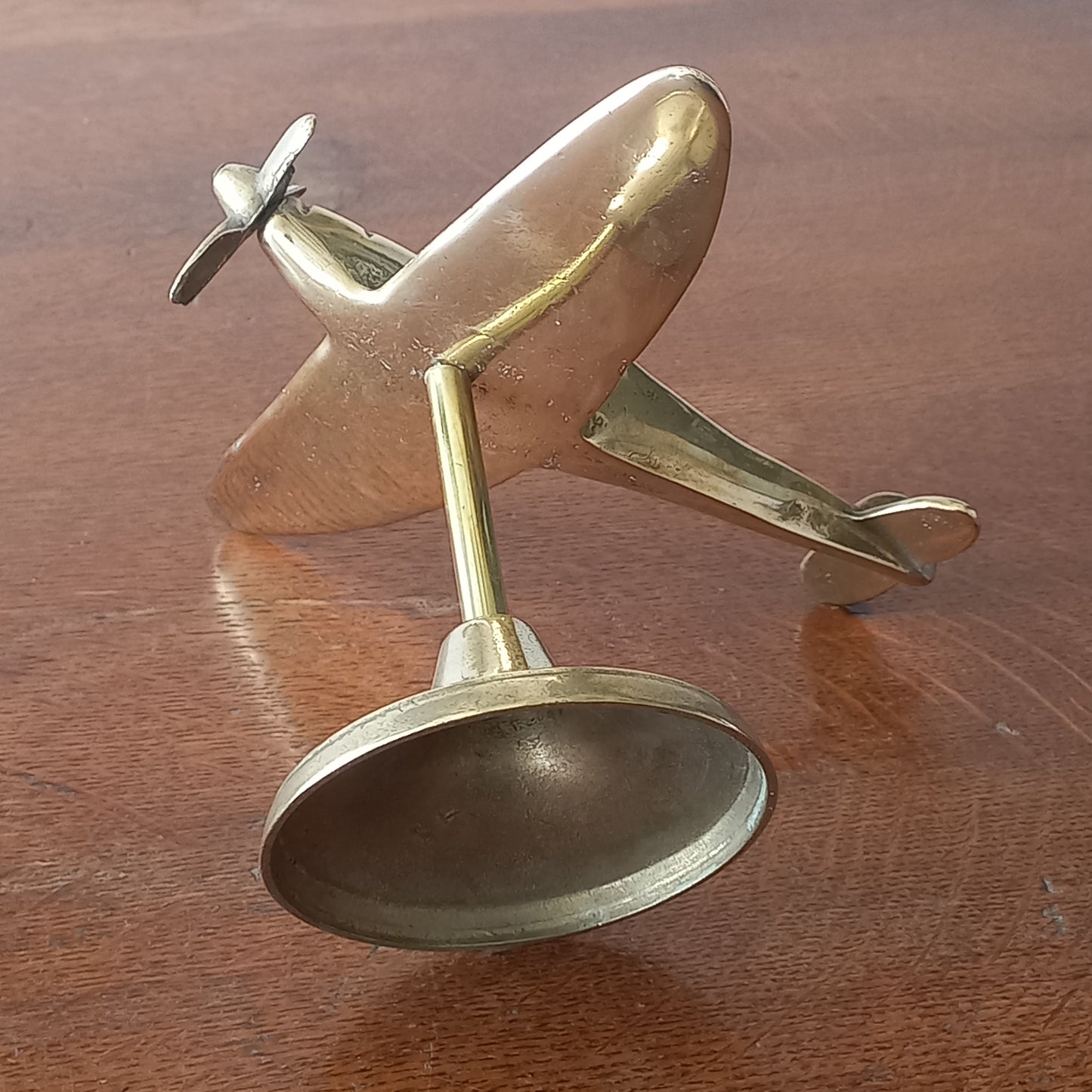 Brass airplane model on a wooden surface