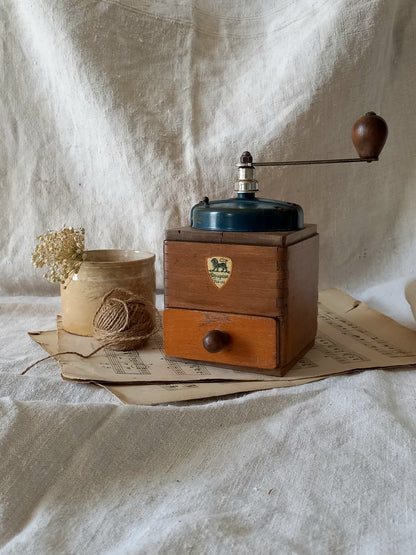 Vintage wooden coffee grinder on a textured fabric background