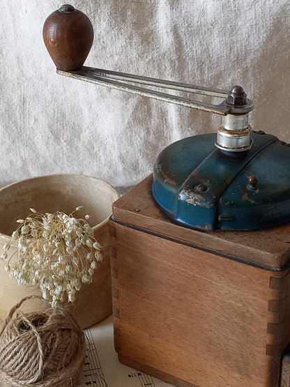 Vintage coffee grinder on a wooden base with a rustic background