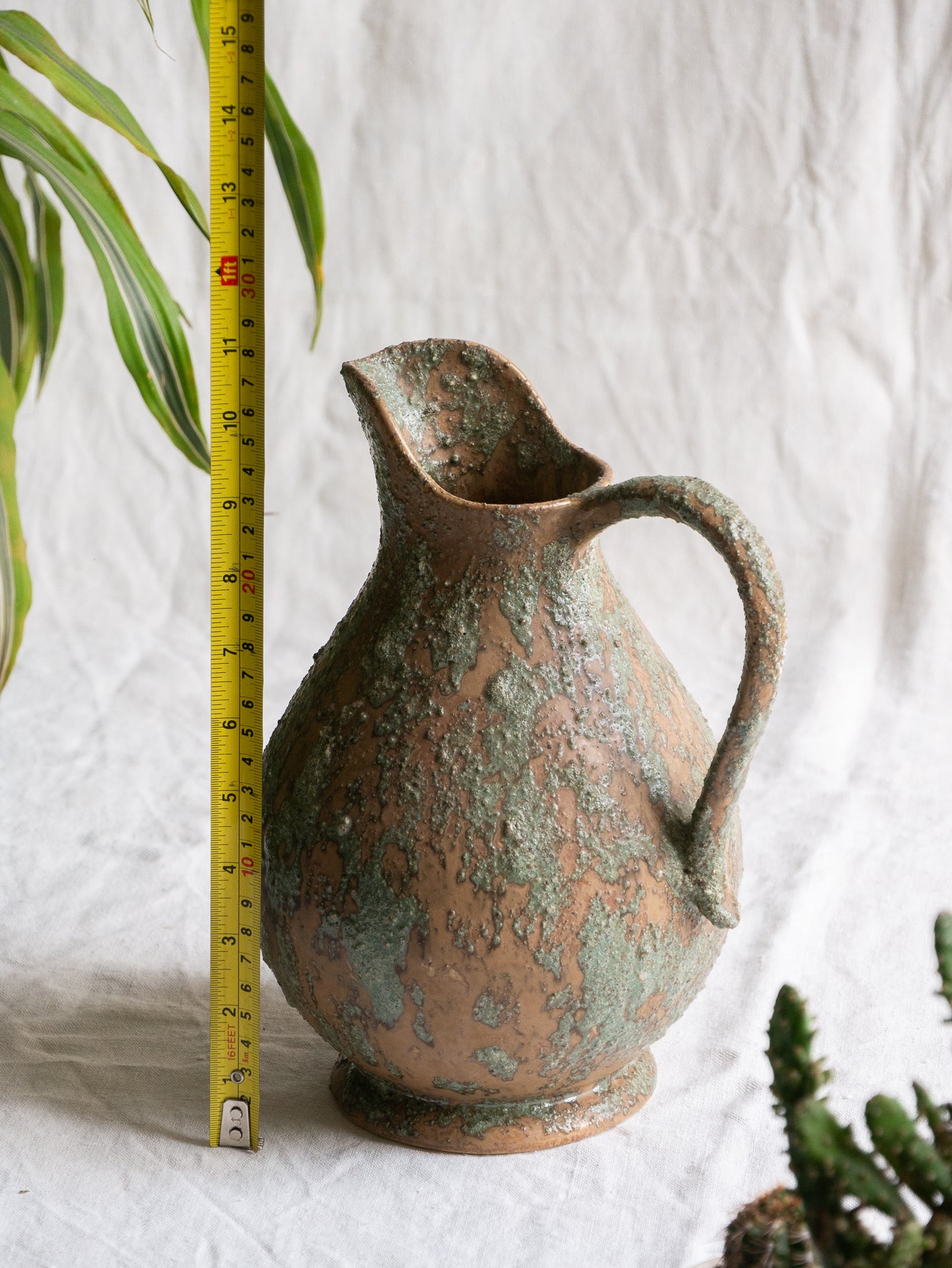 An artisan-made vintage pottery pitcher or jug that purchased in south west France. This piece is wonderful in its earthy tones of brown with a green pattern in relief all over the pitcher and would make a great piece of home decor or addition to a pottery/stoneware collection.